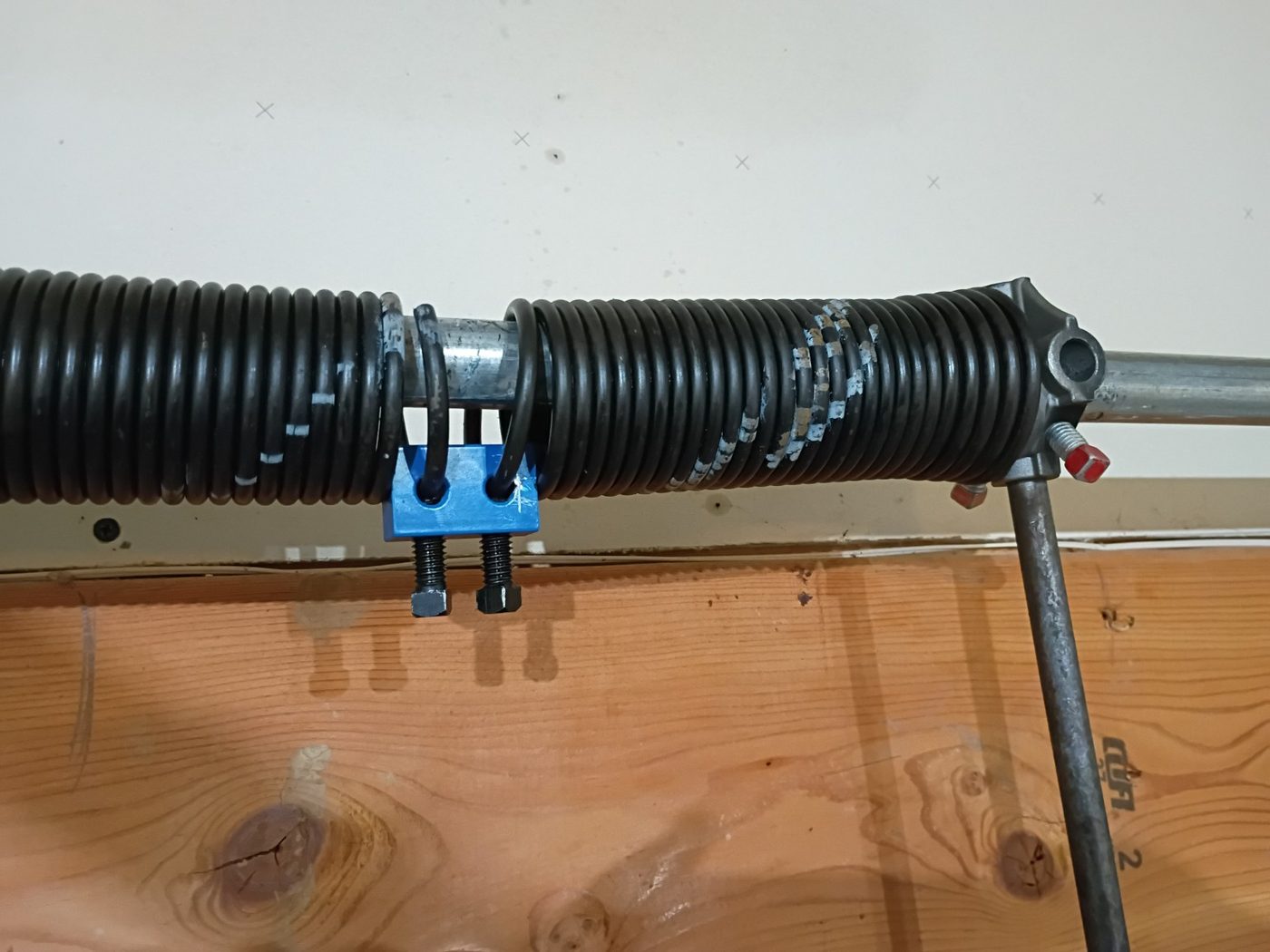 A broken garage door torsion spring showing a clear separation in the coils during a repair