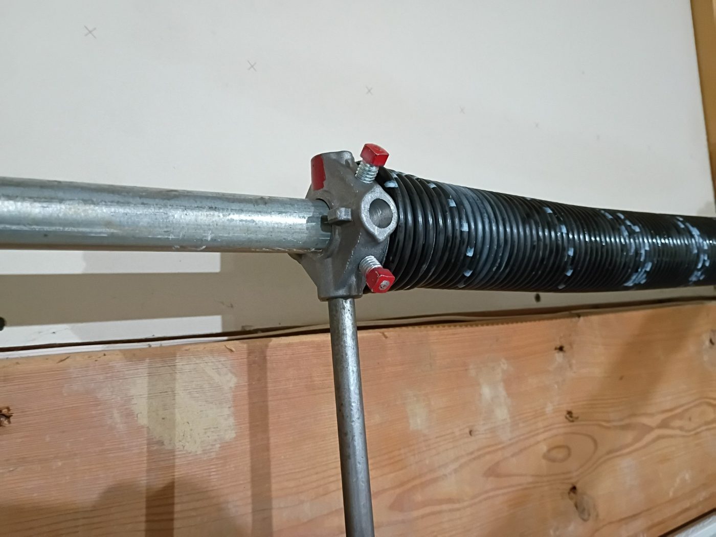 Close-up of a garage door torsion spring and winding cone mounted on the torsion shaft